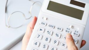 電卓を手に持って計算する様子