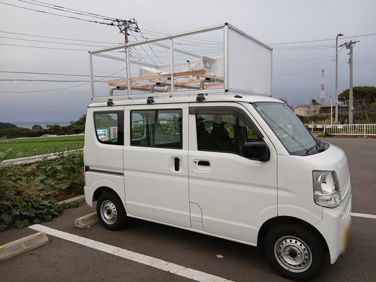 看板の枠（やぐら）とスピーカーを取り付けた軽バンの選挙カー